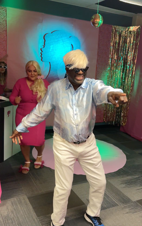 winner Educational Opportunity Program: Barbie Land staff dressed as Ken and Barbie dancing in decorated office 